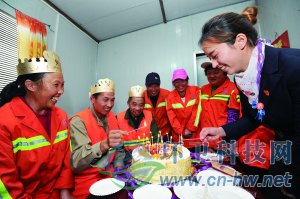 社區(qū)工作人員為集體過生日的三名環(huán)衛(wèi)工人點(diǎn)上生日蠟燭。 本報通訊員 趙松 攝